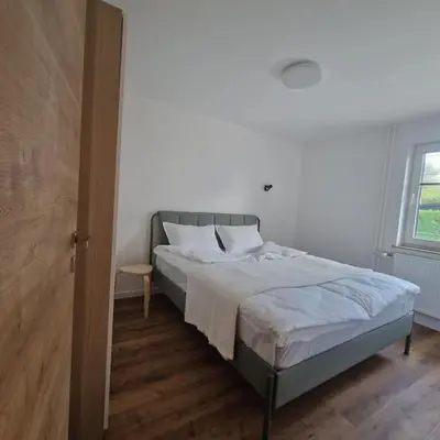 a bedroom with a bed with white sheets and a window at Apartment Little Heaven in Zbilje