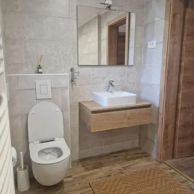 a bathroom with a white toilet and a sink at Apartment Little Heaven in Zbilje