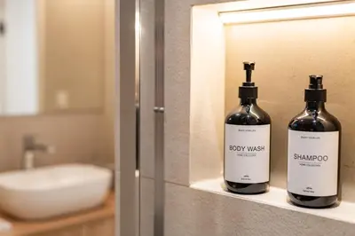 two bottles of wine sitting on a shelf in a bathroom at Trubarjeva City apartments in Ljubljana