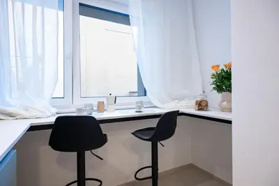 a kitchen with two black chairs sitting at a counter at Trubarjeva City apartments in Ljubljana
