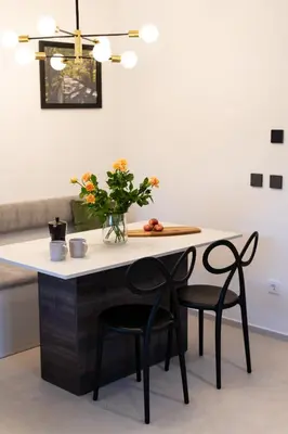 a table with two chairs and a vase with flowers at Trubarjeva City apartments in Ljubljana