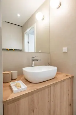 a bathroom with a white sink on a wooden counter at Trubarjeva City apartments in Ljubljana