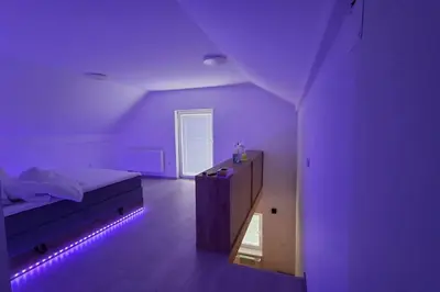 a purple bedroom with a bed with a purple light at Wellness house ZoJa with outdoor sauna and hot tub in Boštanj