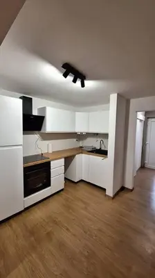 a kitchen with white cabinets and a ceiling fan at Wellness house ZoJa with outdoor sauna and hot tub in Boštanj