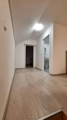 an empty room with white walls and a wooden floor at Wellness house ZoJa with outdoor sauna and hot tub in Boštanj