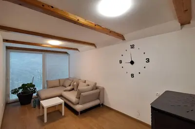 a living room with a couch and a clock on the wall at Wellness house ZoJa with outdoor sauna and hot tub in Boštanj