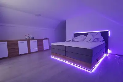 a purple bedroom with a bed with lights on it at Wellness house ZoJa with outdoor sauna and hot tub in Boštanj