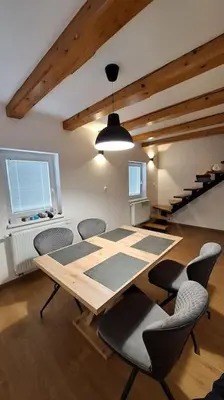 a dining room with a wooden table and chairs at Wellness house ZoJa with outdoor sauna and hot tub in Boštanj