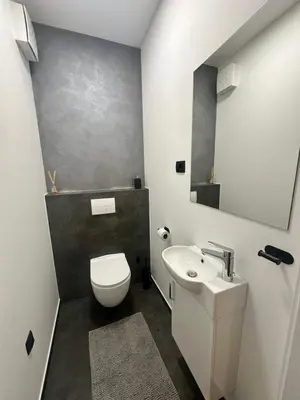 a bathroom with a white toilet and a sink at Lux Apartment in Bovec