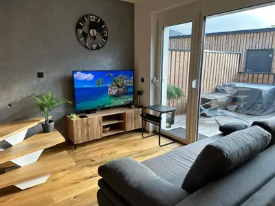 a living room with a couch and a flat screen tv at Lux Apartment in Bovec
