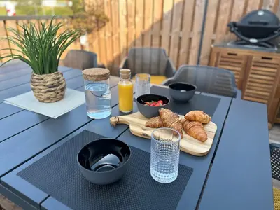 a table with a tray of croissants and orange juice at Lux Apartment in Bovec