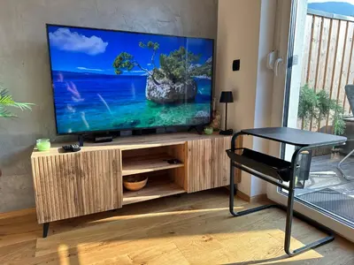 a living room with a flat screen tv on a wooden entertainment center at Lux Apartment in Bovec
