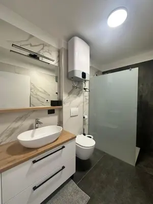 a bathroom with a sink and a toilet and a shower at Lux Apartment in Bovec