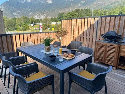 a blue table and chairs on a wooden deck with a table and chairs at Lux Apartment in Bovec