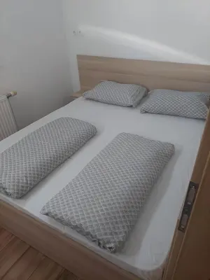 a bed with three pillows on top of it at Puci Apartment in Šmarje-Sap