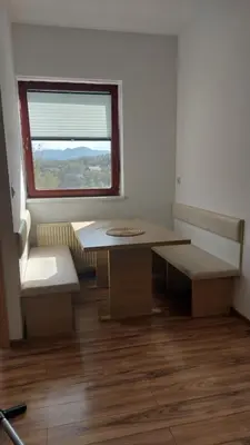 a room with a table and a bench and a window at Puci Apartment in Šmarje-Sap
