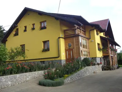 a yellow house with flowers in front of it at Tourist Farm Ob izviru Krupe in Semič