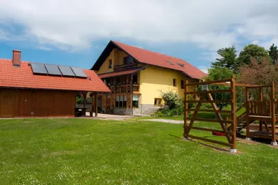 a house with solar panels on top of a yard at Tourist Farm Ob izviru Krupe in Semič