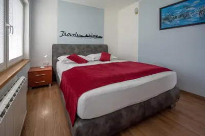 a bedroom with a large bed with a red blanket at Apartment Anja in Zreče