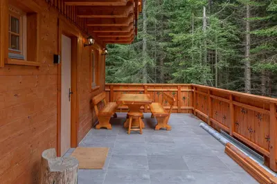 a porch of a cabin with a table and chairs at Luxury Villa TINKA in Zgornje Gorje