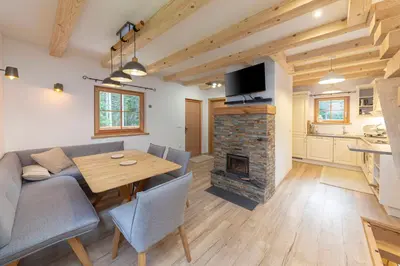 a living room with a wooden table and a fireplace at Luxury Villa TINKA in Zgornje Gorje