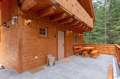 a wooden cabin with a patio and a table at Luxury Villa TINKA in Zgornje Gorje