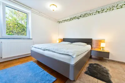 a bedroom with a large bed and a window at Forest View Apartment - Sauna & Nature Escape in Slovenska Bistrica