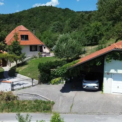 a car parked in a garage next to a house at Forest View Apartment - Sauna & Nature Escape in Slovenska Bistrica