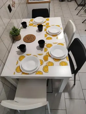 a white table with white plates and oranges on it at Apartma Marko Rogaška in Rogaška Slatina
