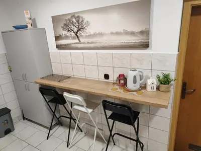 a kitchen with a table with chairs and a picture of a tree at Apartma Marko Rogaška in Rogaška Slatina