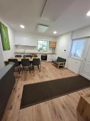 a kitchen with a table and chairs in a room at apartma Pohorc - Macesen in Pohorje