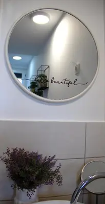 a mirror in a bathroom with a vase of flowers at Poppqi's home in Polzela