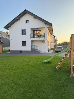 a house with a slide in a yard at Erika's home - apartment house in Šenčur