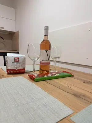 a bottle of wine and two wine glasses on a table at Erika's home - apartment house in Šenčur