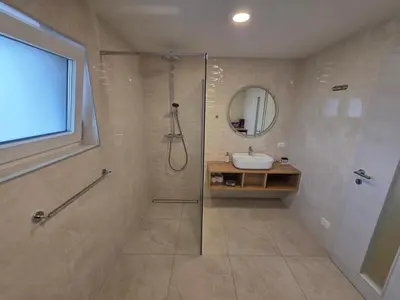 a bathroom with a shower and a sink and a mirror at Erika's home - apartment house in Šenčur