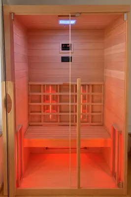 a sauna with a wooden floor and a red wall at Erika's home - apartment house in Šenčur