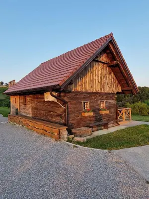 a large wooden cabin with a red roof at Cottage in Stara Gora 45720 in Debenec