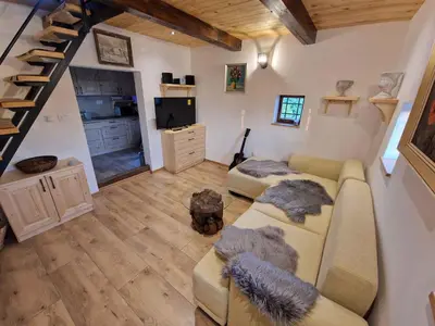 a living room with a couch and a staircase at Cottage in Stara Gora 45720 in Debenec