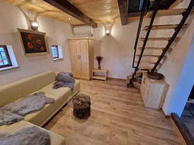 a living room with a couch and a staircase at Cottage in Stara Gora 45720 in Debenec