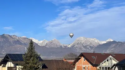 a hot air balloon in the sky over mountains at Riverbank - Mountain view in Radomlje