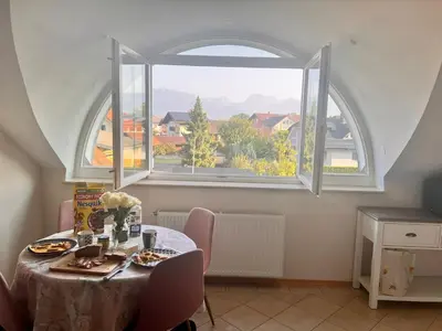 a dining room with a table and a large window at Riverbank - Mountain view in Radomlje