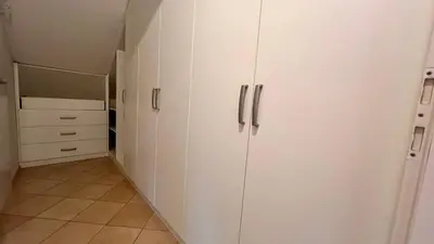 a white closet with white cabinets and a tile floor at Riverbank - Mountain view in Radomlje