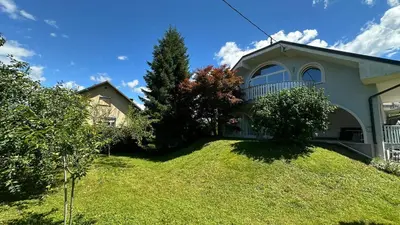 a house with a grassy yard in front of it at Riverbank - Mountain view in Radomlje