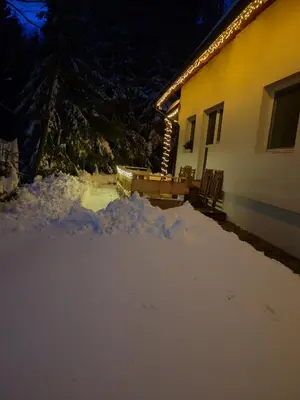 a pile of snow in front of a house at apartma Pohorc - Praprot in Pohorje
