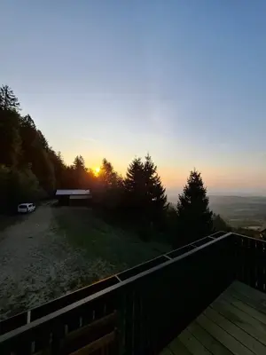 a view of the sunset from a balcony of a house at apartma Pohorc - Praprot in Pohorje