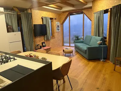 a kitchen and living room with a couch and a table at Lojzov toplar Modern haystack in Velike Lašče