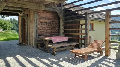 a wooden cabin with a bench and a table at Lojzov toplar Modern haystack in Velike Lašče