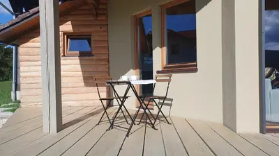 a table and two chairs on a porch of a house at Lojzov toplar Modern haystack in Velike Lašče