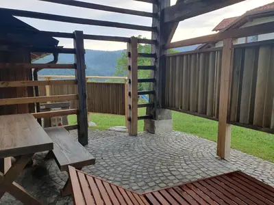 a wooden deck with a bench and a table at Lojzov toplar Modern haystack in Velike Lašče