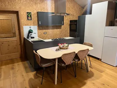 a kitchen with a table and chairs in a kitchen at Lojzov toplar Modern haystack in Velike Lašče